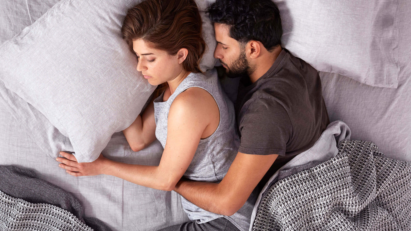 Keetsa Tea Leaf Traditional Pillow shown in use by a couple sleeping comfortably on their sides, highlighting its traditional shape and balanced loft that supports natural head and neck alignment for restful, undisturbed sleep.