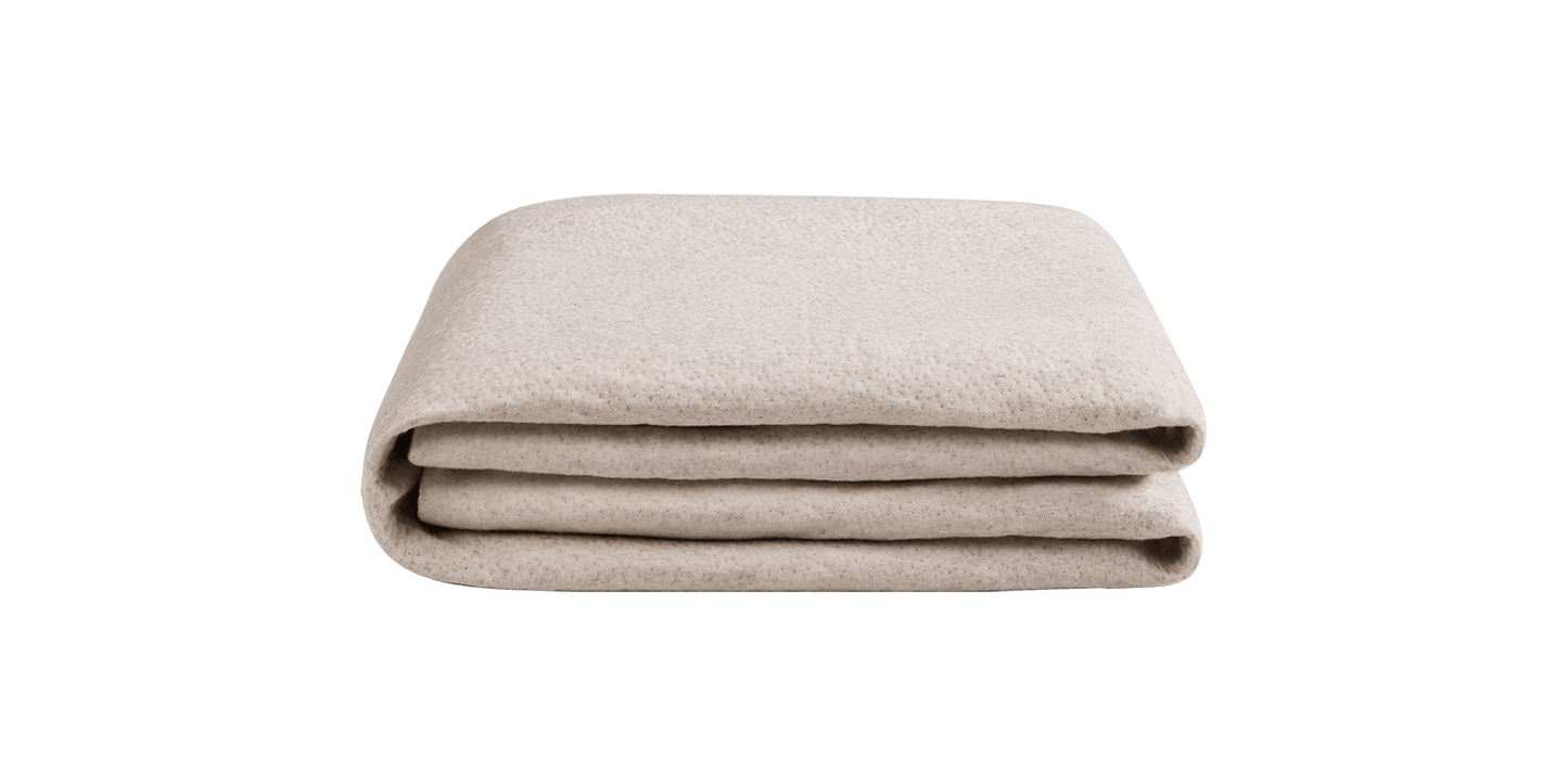 Keetsa waterproof mattress protector neatly folded in cream, displaying soft textured hemp fabric surface in compact stackable form for easy storage.