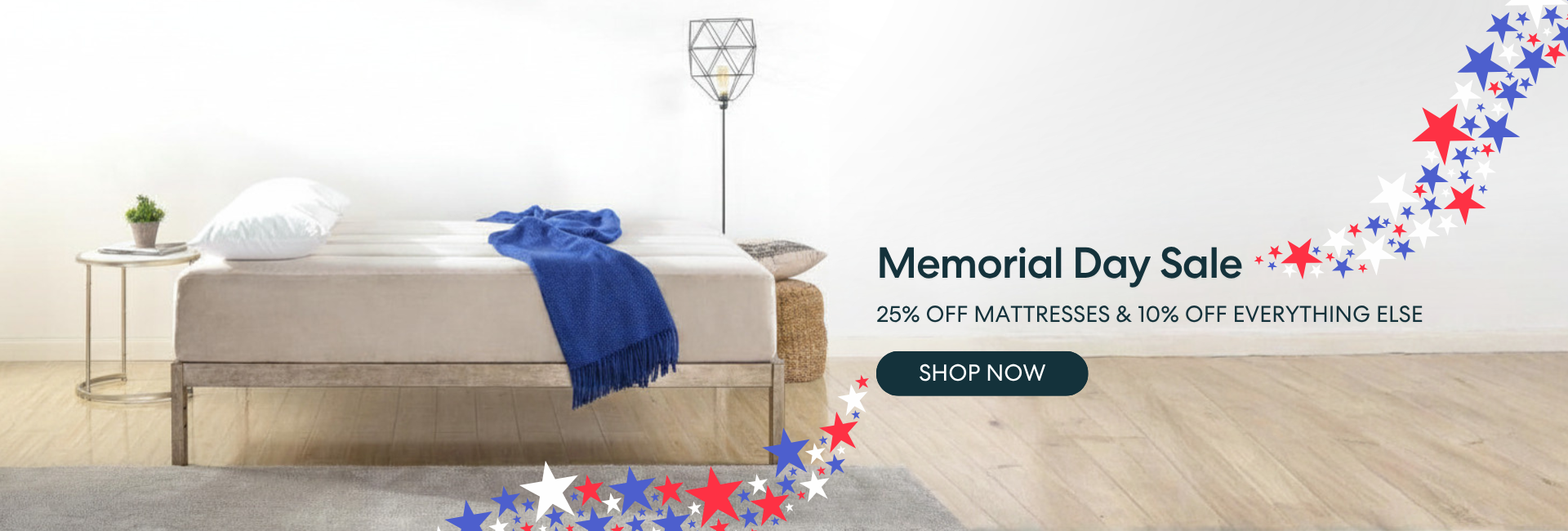 Memorial Day mattress sale offering 25% off mattresses and 10% off everything else, shown with a modern bedroom featuring a low-profile bed, blue throw blanket, and patriotic red, white, and blue stars; includes a “Shop Now” call to action.