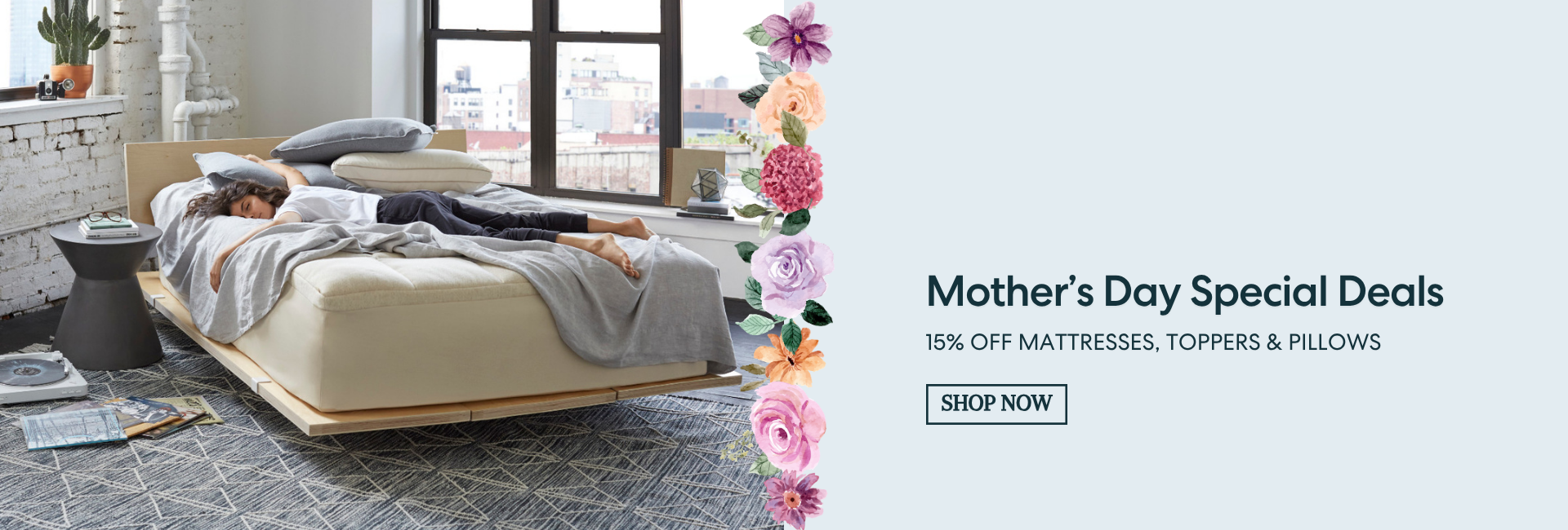 Advertisement for Mother's Day special deals on mattresses, toppers, and pillows with a bed and flowers in the background.
