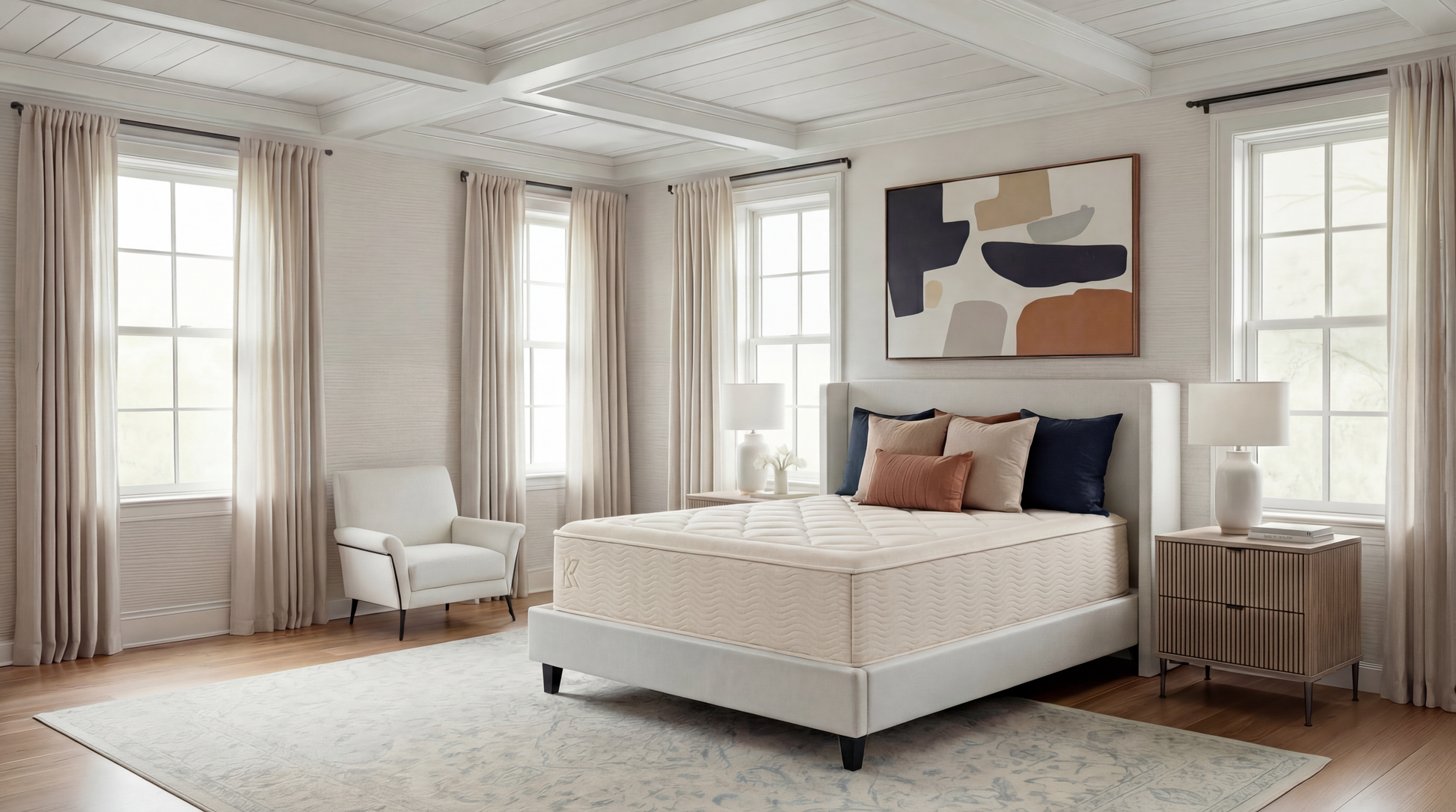 Keetsa Dream mattress on upholstered platform bed in airy traditional bedroom with coffered ceiling, navy and terracotta accent pillows, flanked by fluted wood nightstands and ceramic table lamps