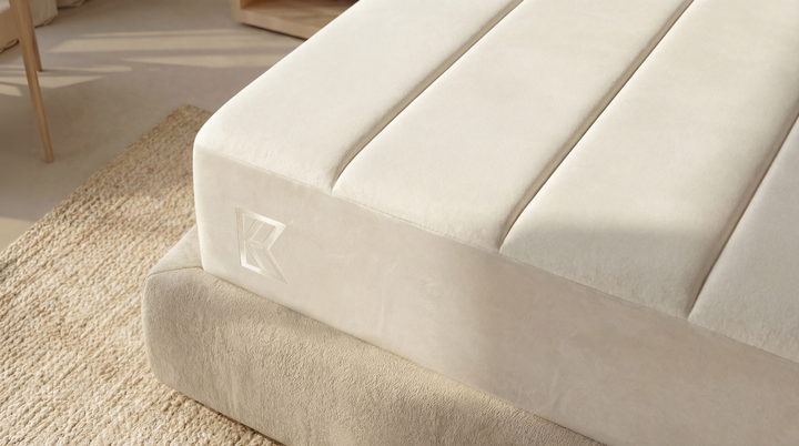 Close-up corner of Keetsa Supreme mattress showing quilted channel-stitched cover, structured edge support, and embossed Keetsa logo on cream fabric panel resting on platform base.
