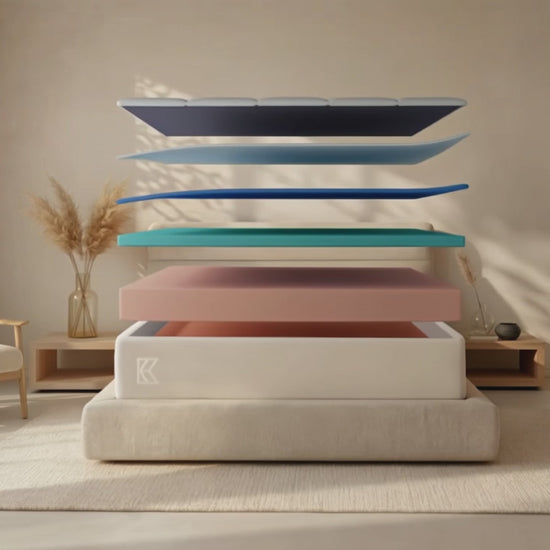 Keetsa Supreme soft memory foam mattress animation: separated layers float above an upholstered platform bed in a sunlit neutral bedroom, then settle into the finished 12-inch coil-free mattress as warm evening light fills the room.
