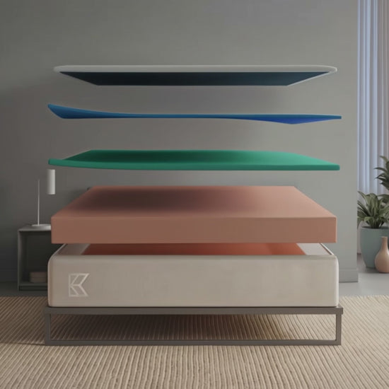 Keetsa Cloud firm memory foam mattress animation: separated layers float above a metal platform bed in a bright bedroom, then settle into the finished 10-inch coil-free mattress as the room shifts to evening light.