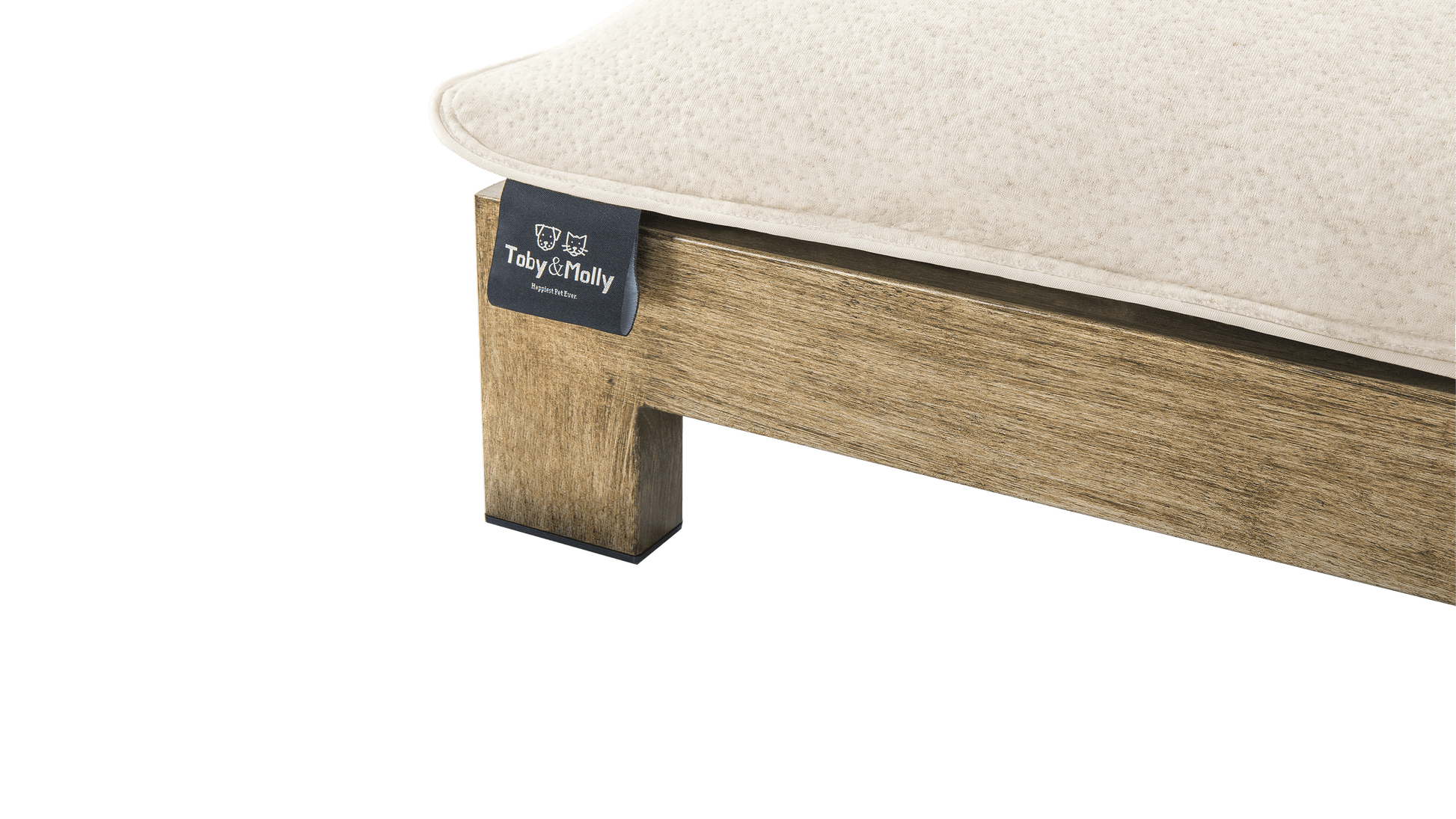 Zinus Toby & Molly pet bed close-up of corner showing cream cushion resting on rustic wood frame with branded Toby & Molly tag reading Happiest Pet Ever and sturdy square leg.