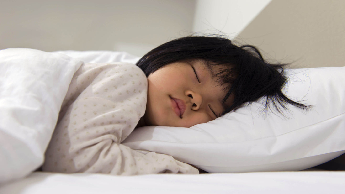 Keetsa Anti-Mite and Sweat-Resistant Pillow Protector shown in use by a sleeping child, highlighting breathable, protective fabric designed to create a clean sleep surface while helping guard against dust mites and moisture buildup for healthier rest.
