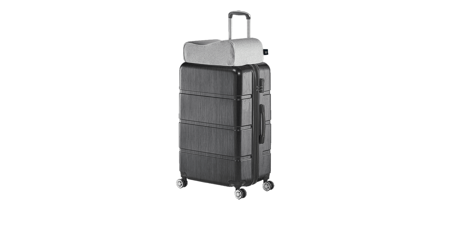 Keetsa Siesta pillow in heather gray resting on top of carry-on suitcase handle, demonstrating compact travel-friendly design for portable neck support on the go.