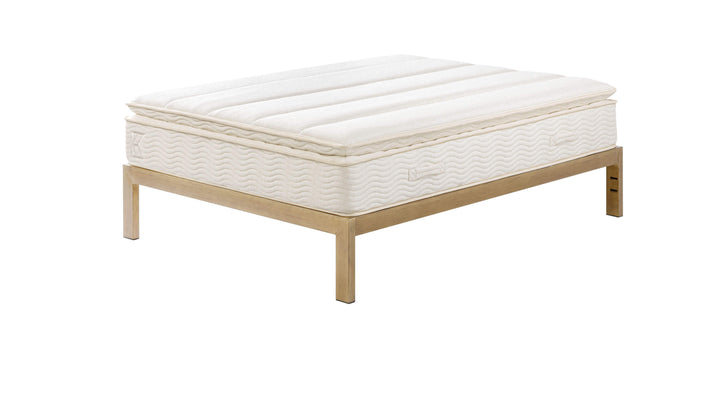 Keetsa Pillow Plus mattress positioned on a wooden platform bed frame, illustrating its elevated pillow-top design and compatibility with modern bed foundations.